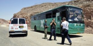 Israeli emergency personnel stand near a bus north of Red Sea resort of Eilat