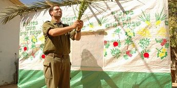 IDF soldier building a sukkah