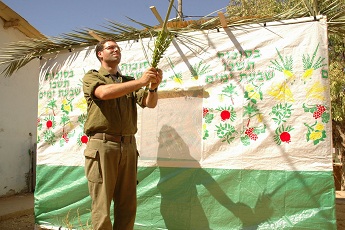 IDF soldier building a sukkah