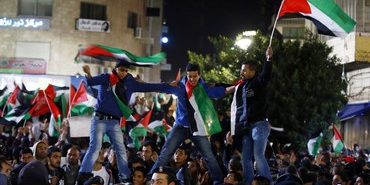 Palestinians celebrate as they take part in a rally in the West Bank city of Ramallah