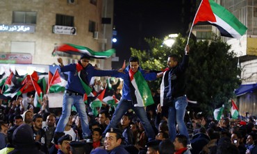 Palestinians celebrate as they take part in a rally in the West Bank city of Ramallah