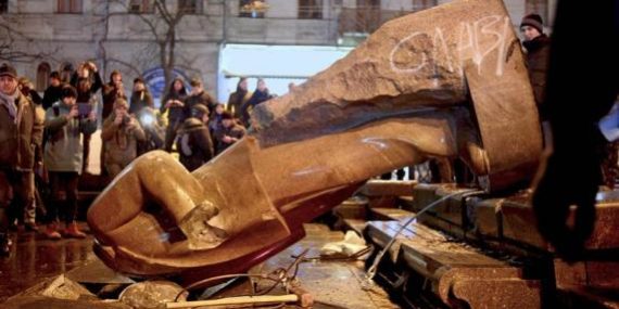 Protesters topple a statue of Soviet state founder Vladimir Lenin with a hawser during a rally organized by supporters of EU integration in Kiev