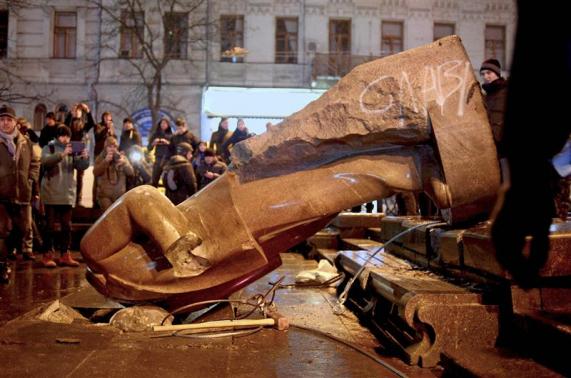 Protesters topple a statue of Soviet state founder Vladimir Lenin with a hawser during a rally organized by supporters of EU integration in Kiev
