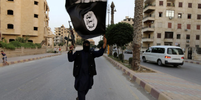A member loyal to the ISIL waves an ISIL flag in Raqqa