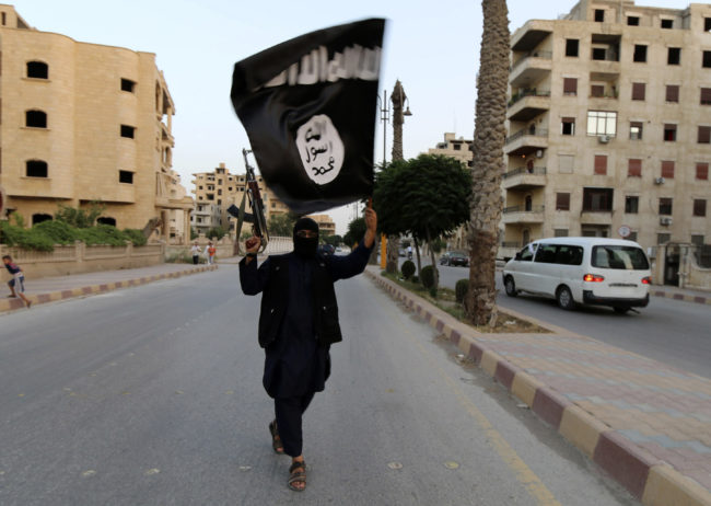 A member loyal to the ISIL waves an ISIL flag in Raqqa