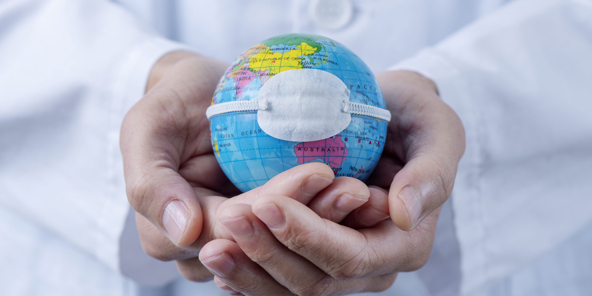 doctor man showing a globe with a mask