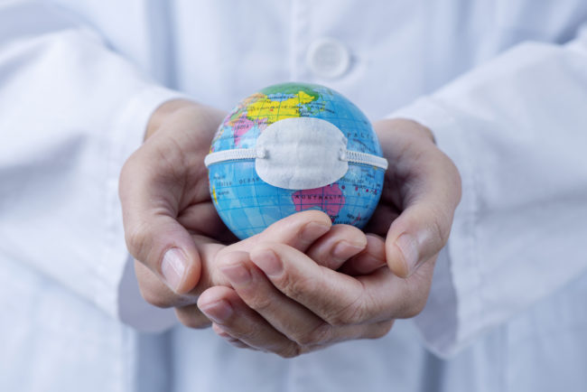 doctor man showing a globe with a mask
