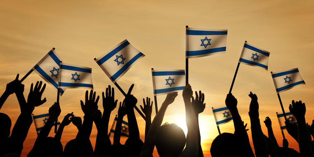 Silhouettes of People Waving the Flag of Israel
